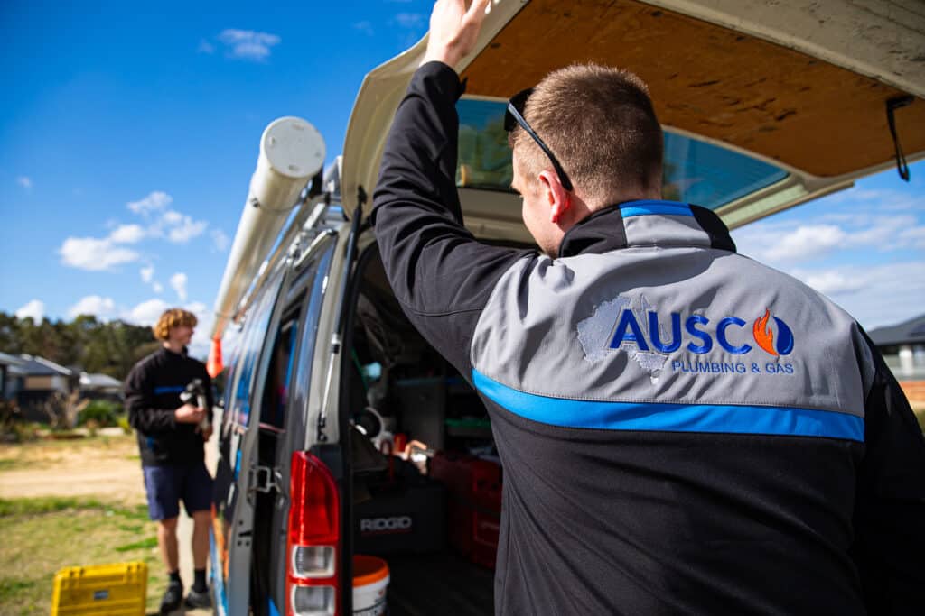 Ausco Plumbing & Gas team outside branded van gathering tools