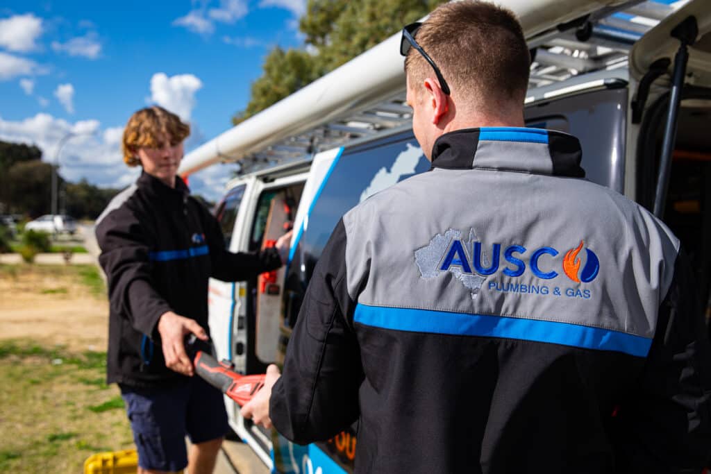 Ausco Plumbing & Gas team outside branded van gathering tools