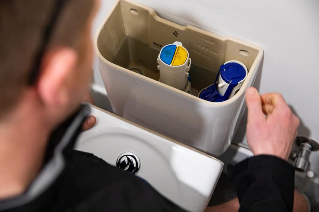Ausco Plumbing & Gas team member working on a toilet cistern
