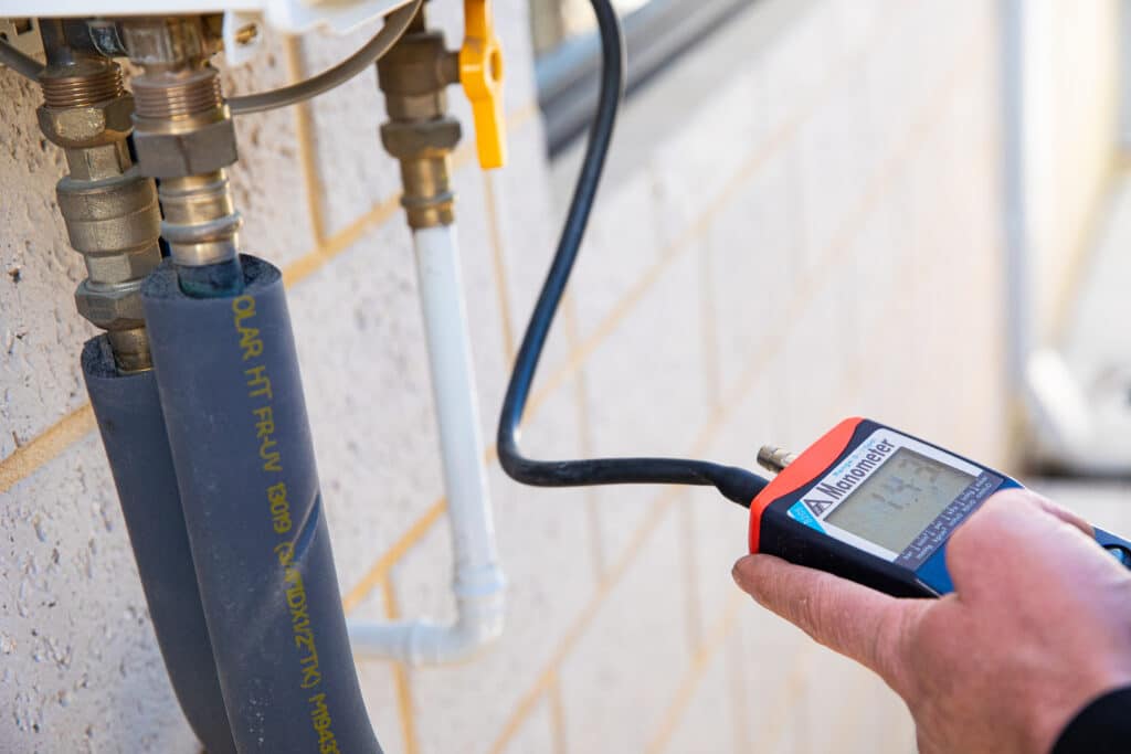 Ausco Plumbing & Gas team member using a Manometer measuring device
