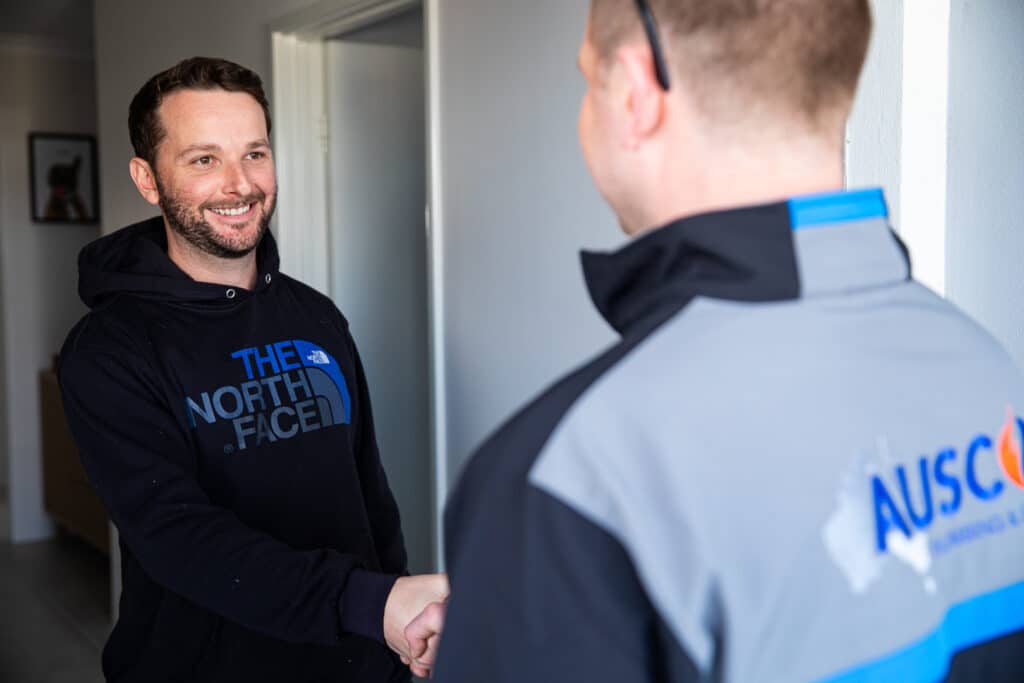 Ausco Plumbing & Gas team member shaking hands with a client