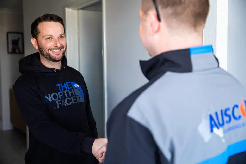 Ausco Plumbing & Gas team member shaking hands with a client